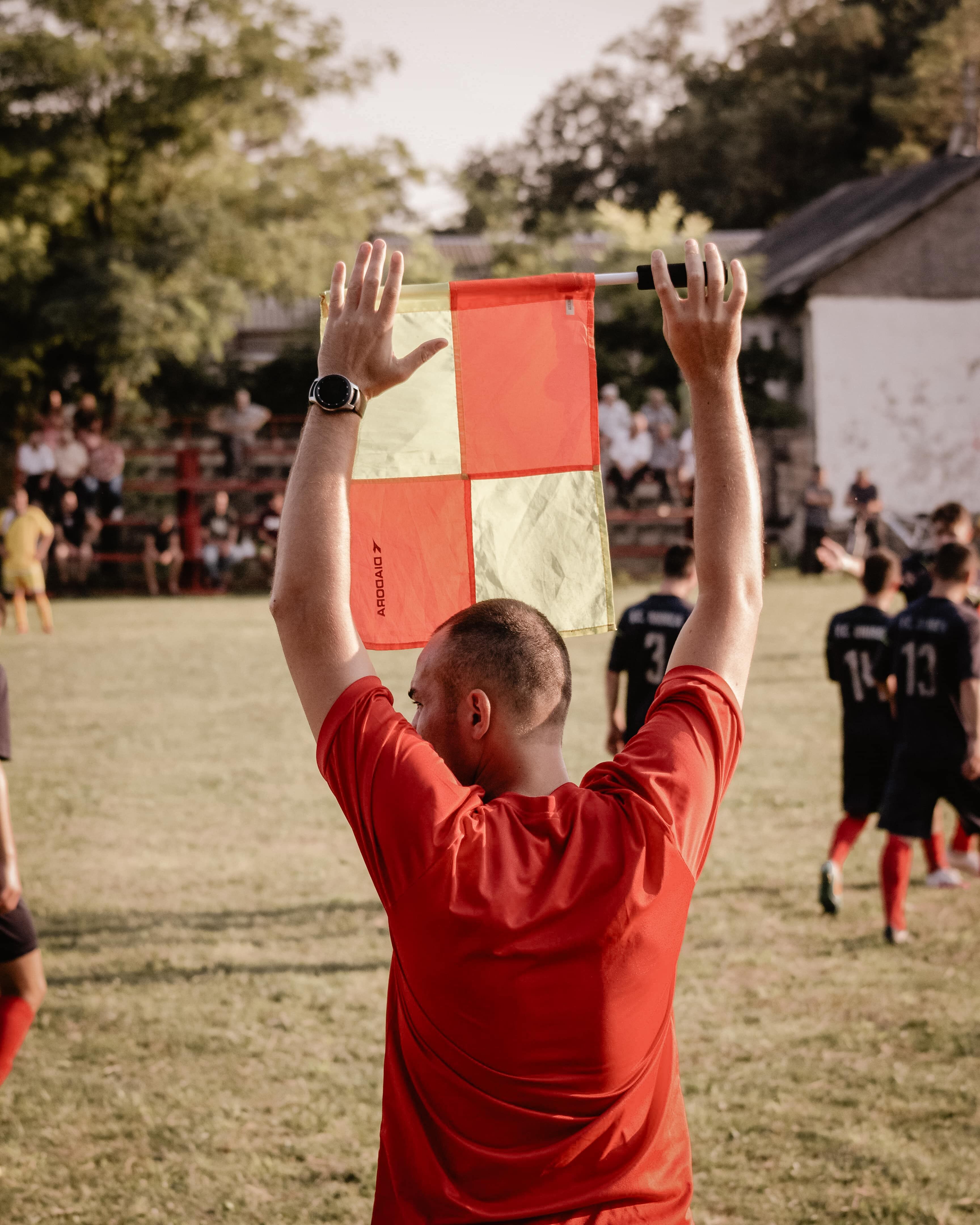 Arbitre assistant tenant un drapeau sur un terrain de football